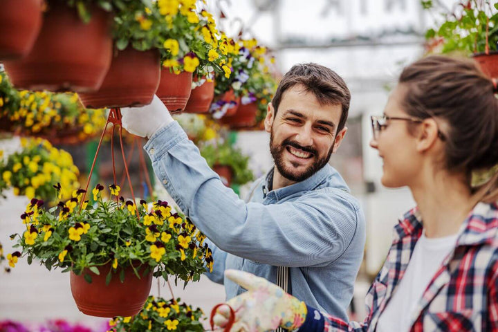 Couple Hanging Flowers in Greenhouse